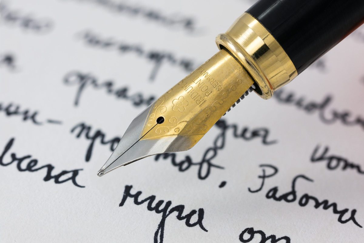 Fountain pen nib writing on paper, close up