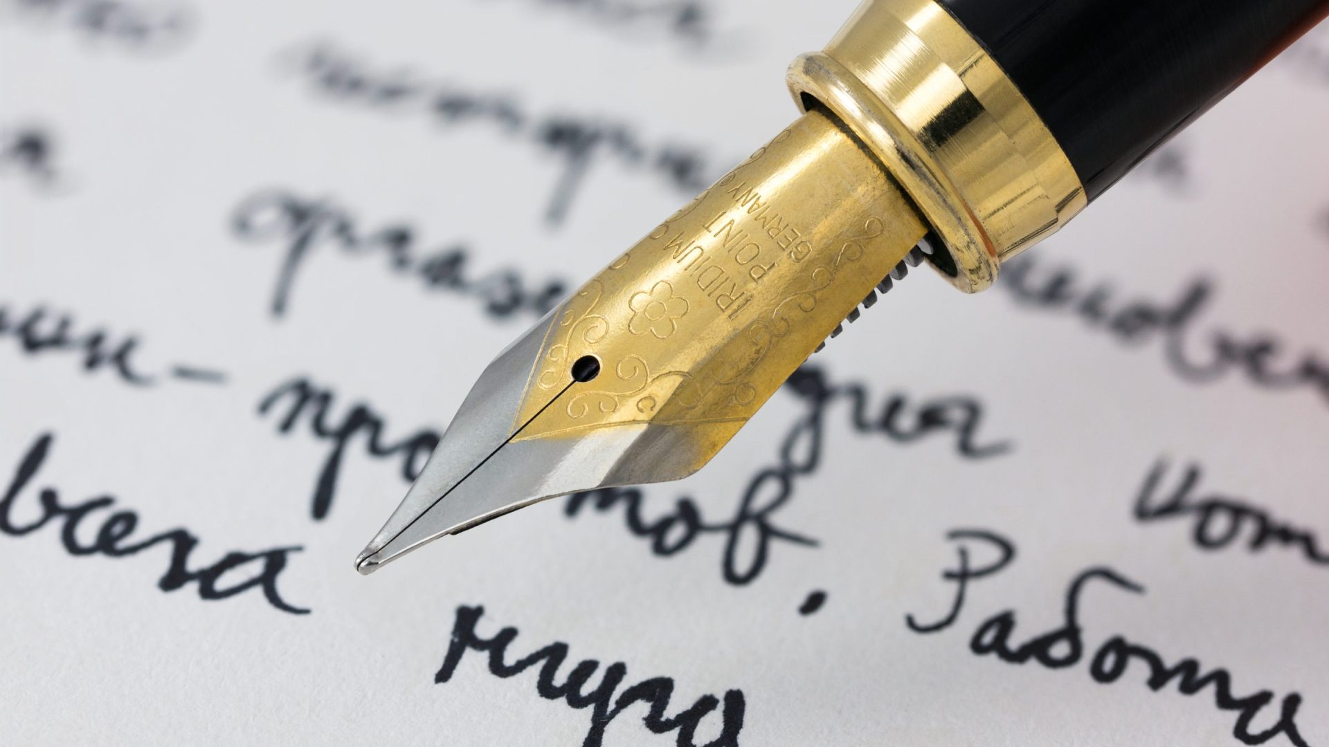 Fountain pen nib writing on paper, close up